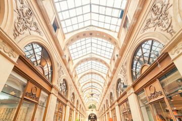 Elegant shopping arcade with a glass ceiling and decorative details.