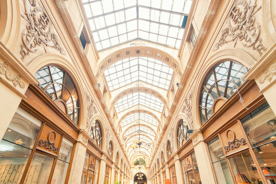 Elegant shopping arcade with a glass ceiling and decorative details.
