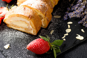 Sliced rolls with custard. The dessert is decorated with fresh strawberries