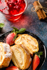 Sliced rolls with custard. The dessert is decorated with fresh strawberries