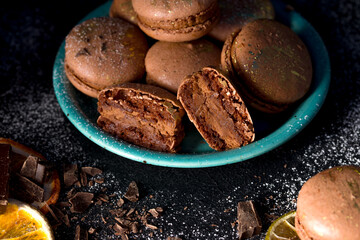Macaroons with chocolate cream on a dark background