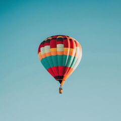Fototapeta premium A colorful hot air balloon floating in a clear blue sky.