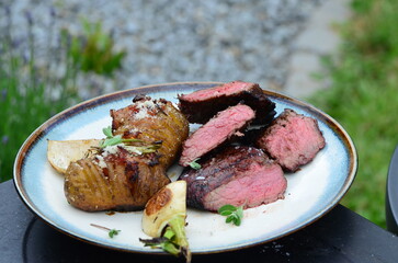Juicy grilled veal with fresh herbs and perfectly charred vegetables, served in a rustic outdoor summer setting