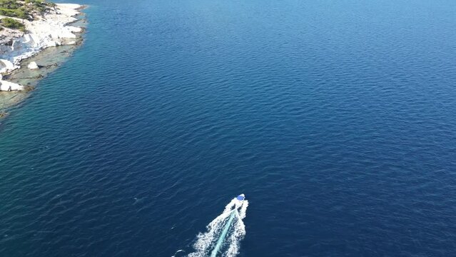 Alyki quarry and beach with speedboat passing in the aegean waters off Thassos, greece