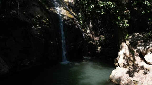 View of the upper waterfall of Theologos with sun filtering through