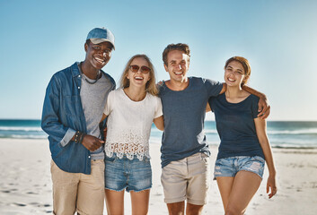 Smiling, friends and hug in portrait on beach in summer for vacation, holiday and bonding or recreation. Happy, men and women embrace seaside for sunset, reunion and adventure or in bali for weekend