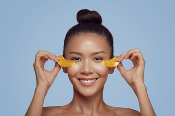 Asian beauty young woman care her skin with gold eye masks patches under eyes 