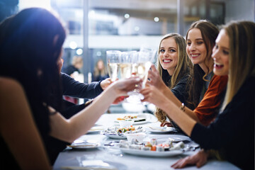 Friends, happy and toast in restaurant for party, event or nightlife, bonding and friendship with...