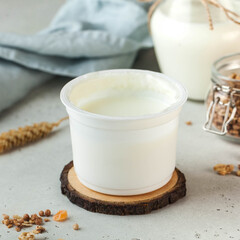 Creamy natural yogurt in a simple white container, perfect for a healthy and nutritious snack.