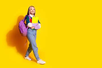 Full size photo of smart nice woman wear stylish shirt hold notebooks go to college empty space isolated on yellow color background