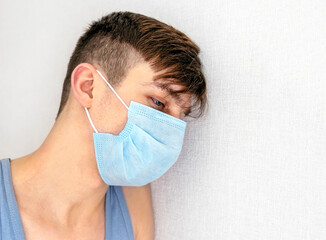 Sad and Sick Young Man in a Flu Mask