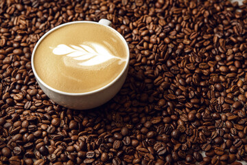 Close-Up View of Latte With Artful Foam on Bed of Coffee Beans