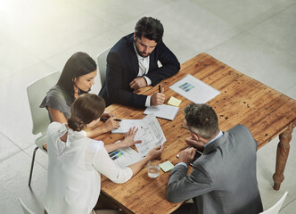 Architect, meeting and business people with blueprint in office for review, discussion or renovation project. Lens flare, architecture firm and employees for conversation, floor plan or teamwork