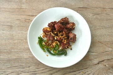 fried crispy fermenting sour pork bone with crispy garlic and chili on plate 