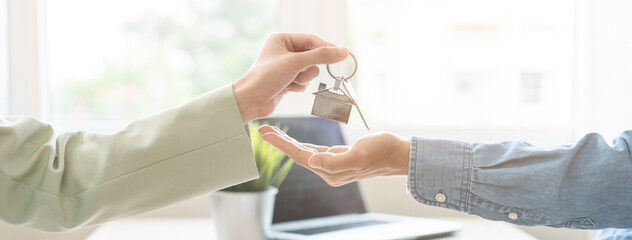Asian agent giving a key to new owner or tenant, client after signed signature contract rental...