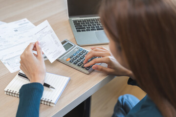 Stressed asian young business woman, employee using calculator to calculate expenses of monthly,...