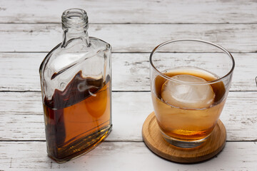 丸い氷のオンザロックとウィスキーのボトル