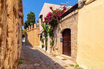 Narrow medieval street with arch and flowers, Rhodes Old Town, Rhodes, Greece