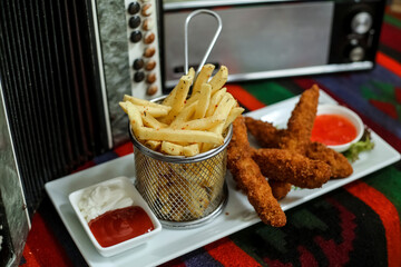 Plate of French Fries and Basket of Ketchup