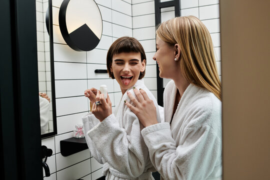 A young woman in a bathrobe flossing her teeth in front of a mirror in a hotel bathroom. - Powered by Adobe