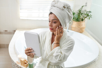 Woman applying face serum after taking bath