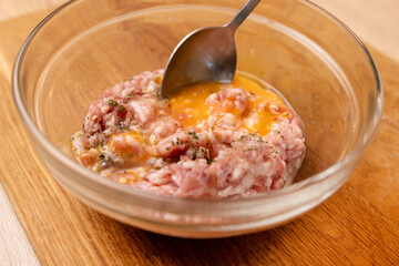 An egg and greens are added to the minced meat. Minced meat for cooking fried meat cutlets.