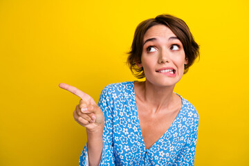 Photo of confused woman with bob hairstyle dressed print blouse indicating look empty space biting...