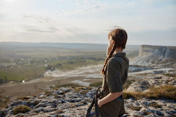 Adventure awaits young woman standing on top of mountain overlooking valley and landscape in travel...