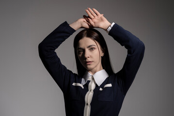 Portrait of attractive caucasian young brunette woman in school uniform in studio. Elegant woman...