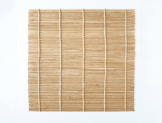 Bamboo rolling screen or sushi roller isolated on white background with clipping path. Also known as Makisu Japanese kitchen utensil for making sushi. Square wooden mat used for forming rolls of sushi