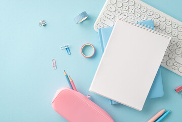 An elegant arrangement of school supplies in pastel colors, featuring a keyboard, notebook, and...