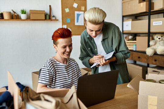 A woman with a laptop, sitting at a table, focused on working or studying. - Powered by Adobe