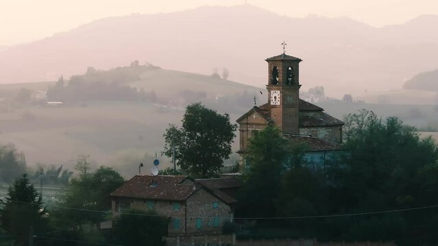 Penango, Piedmont, Italy - 10 11 2023: little medieval church in the province of Asti dramatic aerial drone shot during sunset, with birds and Italian hills in the background