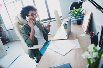 Photo of happy positive broker wear khaki shirt spectacles talking modern device indoors workshop...