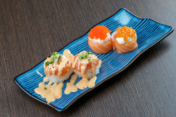 A plate of sushi with salmon, roe, and cream cheese