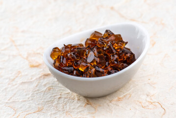 A white bowl filled with amber colored gelatin cubes.