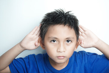 Curious little boy keeps hand near ear for eavesdropping likes gossip, wants to overhear secret...