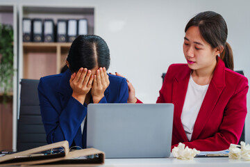 Two Asian businesswomen under stress and pressure discuss financial matters, experiencing anxiety...