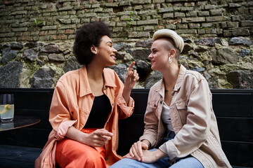 Two women engage in a lively discussion on a park bench.