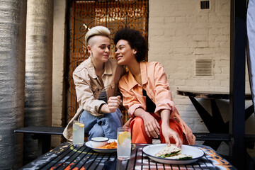 Two women sitting closely together at a table, engaged in conversation and connection.