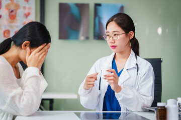 Asian female doctor specializing in psychiatry online consultations from desk, psychotherapy, diagnosis, treatment, counseling to psychiatric patients disorders depression, anxiety, schizophrenia.