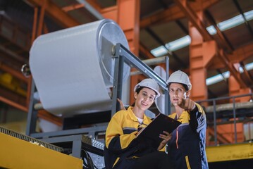 Factory apprenticeship. Man mentor teaching Female employees trainee operating machine looking monitors and check Production process machinery. foreman explaining woman engineer control machine .