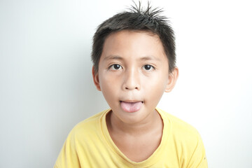 Human Emotions, Reactions And Attitude Concept. Closeup portrait of Asian boy showing sticking out her tongue at camera, playing and having fun. Goofy kid fooling around