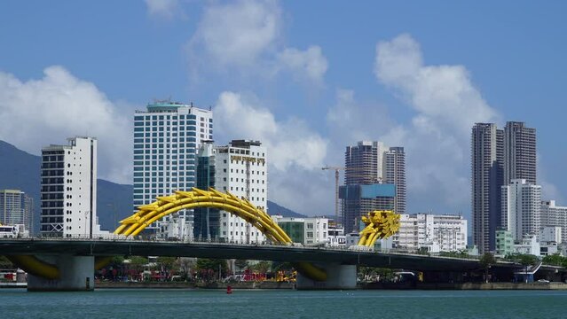 Da Nang, Vietnam - March 9, 2024: Traffic of mopeds and cars driving on the Dragon Bridge 
