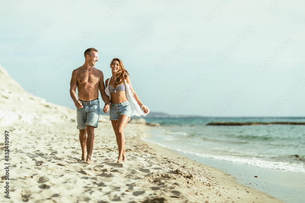 Wall mural Man and Woman Walking on the Beach