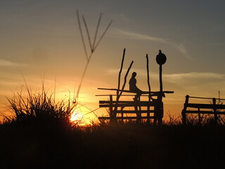 silueta de persona mirando el horizonte en un atardecer