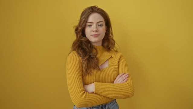 Young caucasian woman wearing sweater standing happy face smiling with crossed arms looking at the camera. positive person. over isolated yellow background