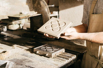 Close-up of Craftsman Displaying Cement Tile With Barcelona Panot Design in Workshop During Daytime