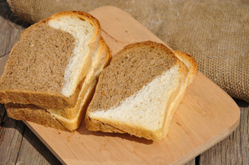 sliced bread on a wooden board. sliced ​​black and white bread on a wooden board. two-color bread.
