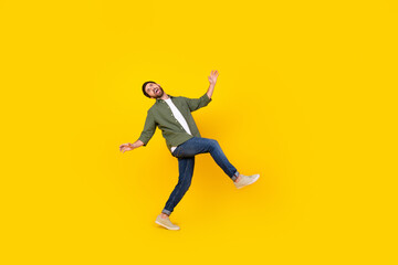 Fototapeta na wymiar Full size photo of nice young man dance walk empty space wear shirt isolated on yellow color background